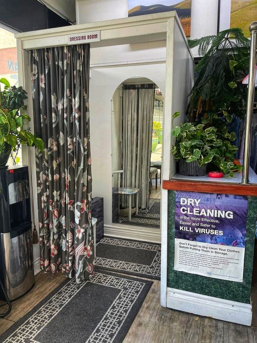 Inside the shop: a curtained dressing room with an arched doorway, potted plants and a patterned entry mat