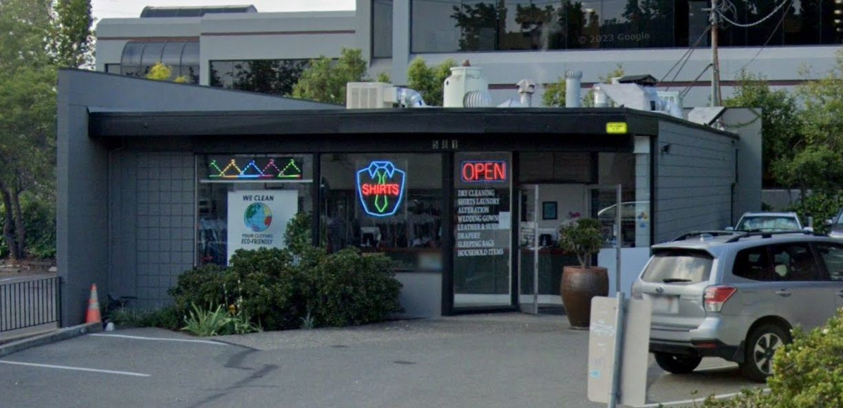 The single-story Walnut Creek Cleaners building on Ygnacio Valley Road, with neon signs in the windows and cars parked in front