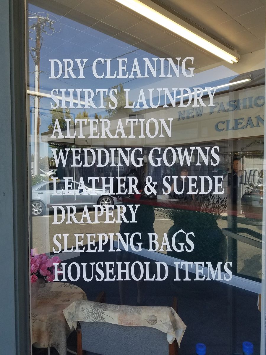 Shop window lettered with Dry Cleaning, Shirts Laundry, Alteration, Wedding Gowns, Leather & Suede, Drapery, Sleeping Bags and Household Items